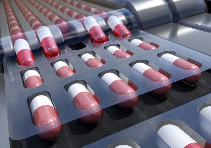 Image description: Red and white capsules (medications) in a production line.